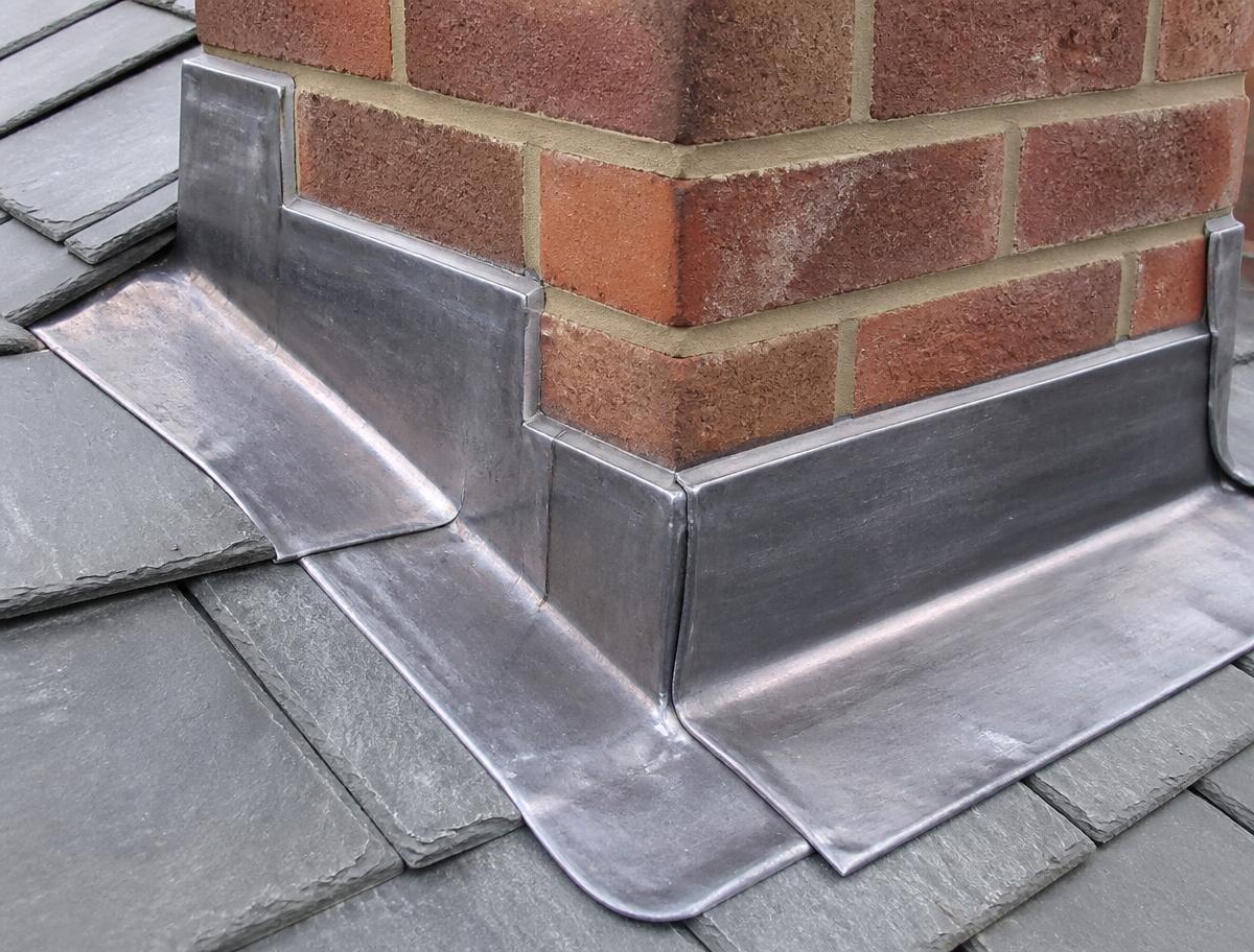 New lead flashing dressed around a brick chimney stack